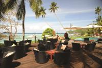 a restaurant with chairs and tables and the ocean at DoubleTree by Hilton Seychelles Allamanda Resort & Spa in Takamaka