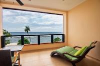 a room with a chair and a large window with the ocean at DoubleTree by Hilton Seychelles Allamanda Resort & Spa in Takamaka