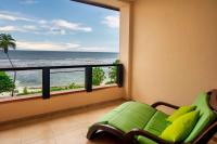a balcony with a couch and a view of the ocean at DoubleTree by Hilton Seychelles Allamanda Resort & Spa in Takamaka
