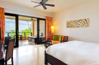 a bedroom with a bed and a living room at DoubleTree by Hilton Seychelles Allamanda Resort & Spa in Takamaka