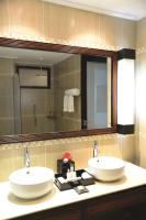 a bathroom with two sinks and a large mirror at DoubleTree by Hilton Seychelles Allamanda Resort & Spa in Takamaka