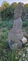 a stone statue sitting in the grass at COCON in La Douze