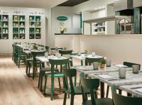 a dining room with tables and green chairs at The Peninsula Chicago in Chicago
