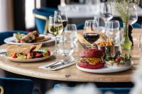 una mesa con platos de comida y copas de vino en Hôtel Restaurant le Touring - Teritoria, en Saint-Raphaël