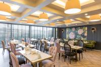 ein Esszimmer mit Tischen, Stühlen und Fenstern in der Unterkunft DoubleTree By Hilton Izmir Airport in Izmir