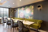 ein Restaurant mit einer grünen Couch sowie Tischen und Stühlen in der Unterkunft DoubleTree By Hilton Izmir Airport in Izmir