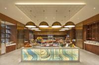 a lobby with a counter with food on it at Hilton Dalian Golden Pebble Beach Resort in Jinzhou