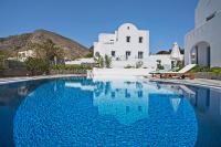 a swimming pool in front of a white building at Felicity Luxury Villas in Kamari