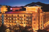 麗江市にあるHilton Garden Inn Lijiangの夜に屋根の上に看板が立っている建物