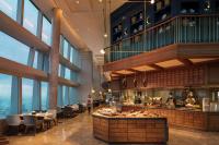 a restaurant with tables and chairs and windows at Conrad Shenyang in Shenyang