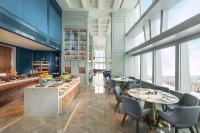 a restaurant with tables and chairs and windows at Conrad Shenyang in Shenyang