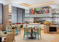 une cuisine et une salle à manger avec tables et chaises dans l'établissement Hilton Garden Inn Jakarta Taman Palem, à Jakarta