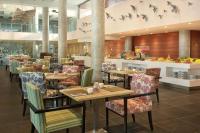 a restaurant with tables and chairs and birds on the wall at Hilton Garden Inn Bali Ngurah Rai Airport in Kuta