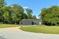 a black building in a field with trees at Le Cottage proche du Golf in Panazol