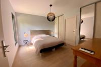 a bedroom with a bed and a table and a mirror at Le Cottage proche du Golf in Panazol