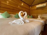 two white swans sitting on a bed in a room at Palm Leaf Resort Koh Tao in Ko Tao
