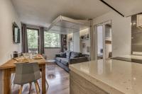 a kitchen and living room with a table and a couch at Aiguille du Grépon - Bright Apartment in the Heart of Chamonix in Chamonix