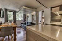 a kitchen and living room with a table and a couch at Aiguille du Grépon - Bright Apartment in the Heart of Chamonix in Chamonix