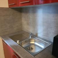 a stainless steel sink in a kitchen with red cabinets at Appartement T2 Brest Pilier Rouge avec internet in Brest
