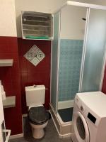 a bathroom with a toilet and a washing machine at L appartement de la plage in Le Barcarès