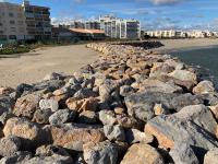 a group of rocks on the beach next to the ocean at L appartement de la plage in Le Barcarès