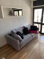 a living room with a couch with pillows on it at L appartement de la plage in Le Barcarès