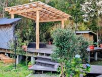 pérgola de madera sobre una escalera de madera en un jardín en Cabañas Kompatzki, en Ancud