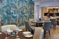 une salle à manger avec des tables et des chaises et une fresque murale. dans l'établissement DoubleTree by Hilton York, à York