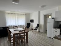 a kitchen and dining room with a table and chairs at Kozákov Apartmány - první patro 