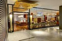 a restaurant with tables and chairs in a building at Hilton Frankfurt Airport in Frankfurt/Main