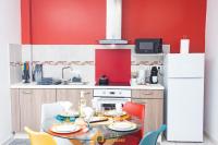 cocina con mesa y pared roja en Le nuancier au centre-ville près du Mcdonald&#39;s, en Cayenne