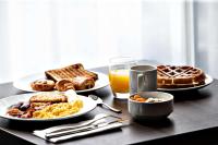 a table with plates of breakfast foods and a glass of orange juice at Hampton By Hilton Toulouse Airport in Blagnac