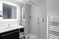 a white bathroom with a sink and a shower at Hampton By Hilton Toulouse Airport in Blagnac