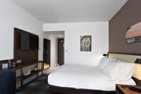 a hotel room with a bed and a flat screen tv at Hampton By Hilton Toulouse Airport in Blagnac