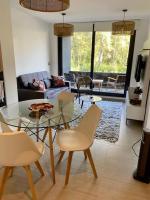 Una sala de estar con una mesa de cristal y sillas. en hermoso departamento 1 dormitorio en entorno natural, en Pucón