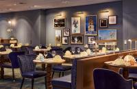 هيلتون دوسلدورف في دوسلدورف: مطعم بطاولات وكراسي وصور على الحائط