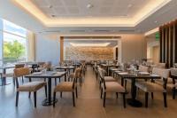 Un gran comedor con mesas y sillas. en Hilton Garden Inn Neuquen, en Neuquén