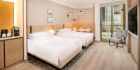 a hotel room with two beds and a window at Sheraton Abu Dhabi Hotel & Resort in Abu Dhabi