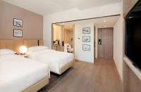 a hotel room with two beds and a mirror at Sheraton Abu Dhabi Hotel & Resort in Abu Dhabi