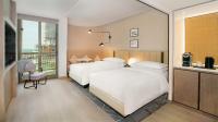 a hotel room with two beds and a balcony at Sheraton Abu Dhabi Hotel & Resort in Abu Dhabi