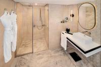 a bathroom with a shower and a sink and a mirror at Sheraton Abu Dhabi Hotel & Resort in Abu Dhabi