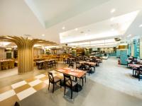 een restaurant met tafels en stoelen in een cafetaria bij Uni-Resort Mawutu in Guanxi