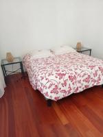 a bed with a red and white blanket on a wooden floor at Appartement au Cœur de Tours, la Ville à Vos Pieds in Tours