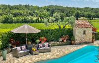 a patio with an umbrella and chairs and a pool at Awesome Home In Fontarches With 2 Bedrooms, Wifi And Outdoor Swimming Pool in Fontarèches