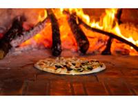 a pizza in front of a fire oven at Grand Palace Hotel Lusaka in Lusaka
