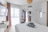 a white bedroom with a large white bed with a pillow at Appart&#39;City Confort Pau Centre in Pau
