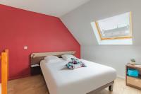 a bed in a room with a red wall at Appart&#39;City Confort Pau Centre in Pau