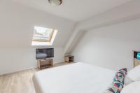 a white bedroom with a bed and a tv at Appart&#39;City Confort Pau Centre in Pau
