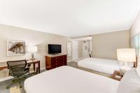 a hotel room with two beds and a desk and a television at Hilton Irvine/Orange County Airport in Irvine