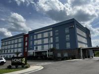 Un edificio azul con un cartel de casa delante. en Home2 Suites By Hilton Hinesville, en Hinesville